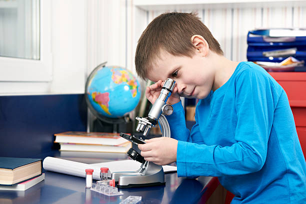 мальчик смотрит в микроскоп